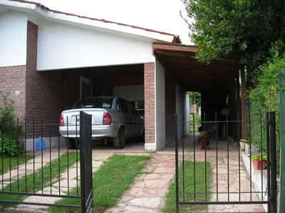 a car parked in a garage next to a house at Departamento Loma Hermosa in Santa Rosa de Calamuchita