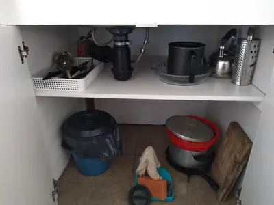 a kitchen shelf with a sink and some pots and pans at Departamento Loma Hermosa in Santa Rosa de Calamuchita