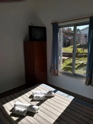 a bedroom with two towels on a bed with a window at Departamento Loma Hermosa in Santa Rosa de Calamuchita