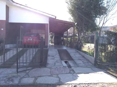a garage with a car parked under a fence at Departamento Loma Hermosa in Santa Rosa de Calamuchita