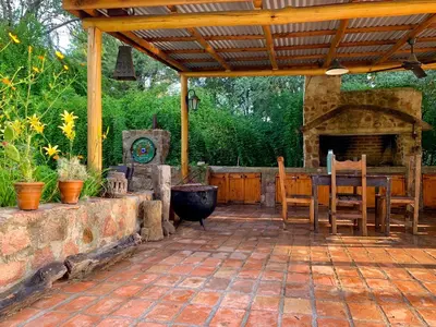 a patio with a stone fireplace and a table and chairs at Casa de campo La Añurita in San Javier
