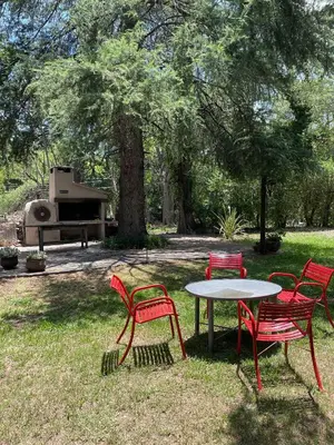 four red chairs and a table in a park with a grill at Casa de campo La Añurita in San Javier