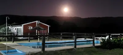 a house with a swimming pool at night at Cabañas Valle del Chutunzo in San Francisco del Monte de Oro