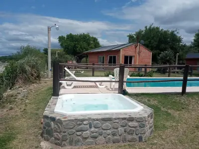 a stone tub in a yard with a house at Cabañas Valle del Chutunzo in San Francisco del Monte de Oro