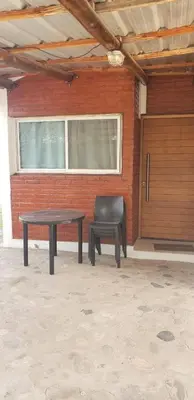 a table and a bench in front of a building at Cabañas Valle del Chutunzo in San Francisco del Monte de Oro