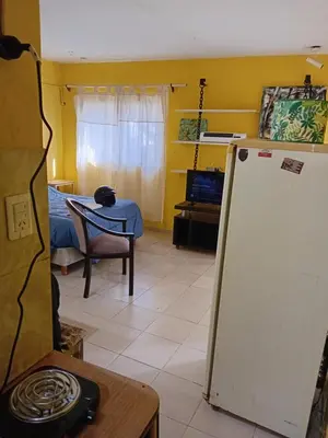 a living room with a refrigerator and a table at Monoambiente Alto Verde in Cordoba