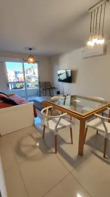 a living room with a table and a couch at Departamentos Premium Opera in Villa Carlos Paz