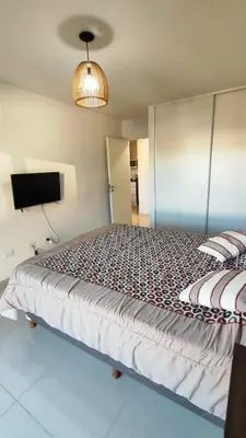 a bedroom with a large bed and a tv at Departamentos Premium Opera in Villa Carlos Paz