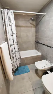 a bathroom with a tub and a toilet and a sink at Departamentos Premium Opera in Villa Carlos Paz