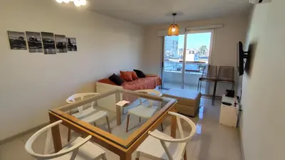 a living room with a table and a couch at Departamentos Premium Opera in Villa Carlos Paz