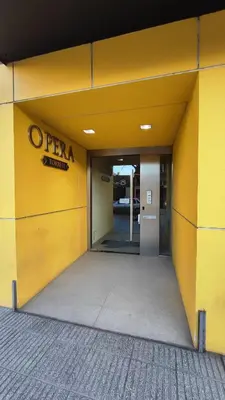an entrance to an office building with a yellow wall at Departamentos Premium Opera in Villa Carlos Paz