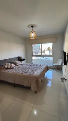 a bedroom with a large bed and a large window at Departamentos Premium Opera in Villa Carlos Paz