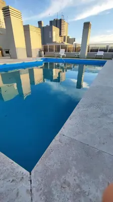 a swimming pool with blue water on top of a building at Departamentos Premium Opera in Villa Carlos Paz