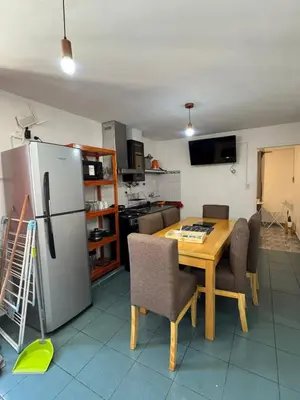 a kitchen with a wooden table and a refrigerator at Depto Quality in Cordoba