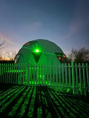 a green tent is behind a white fence at Domo Del Rio in Los Reartes