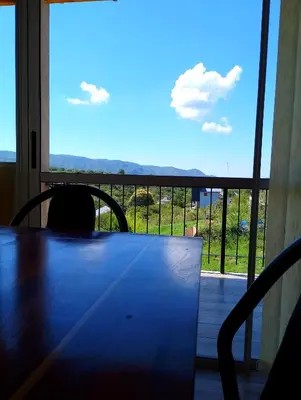 a table in a room with a large window at Cabaña Siegfried in Villa General Belgrano