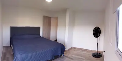 a bedroom with a blue bed in a white room at Cabaña Siegfried in Villa General Belgrano