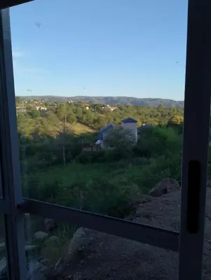 a view from a door looking out at a field at Cabaña Siegfried in Villa General Belgrano