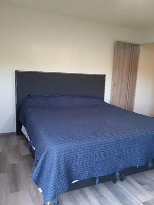 a bed in a bedroom with a blue blanket on it at Cabaña Siegfried in Villa General Belgrano