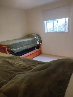 a bedroom with two beds and a window at Cabaña Siegfried in Villa General Belgrano