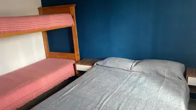 a bedroom with two bunk beds and a blue wall at Cabaña Carmanqui in Alpa Corral
