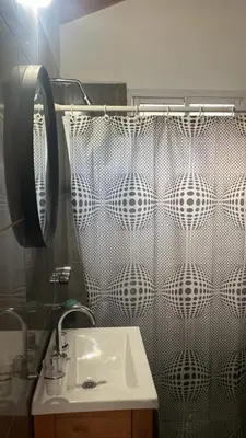 a bathroom with a sink and a shower curtain at Cabaña Carmanqui in Alpa Corral