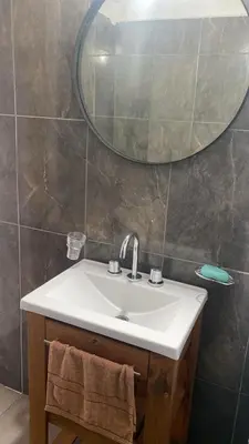 a bathroom with a sink and a mirror at Cabaña Carmanqui in Alpa Corral