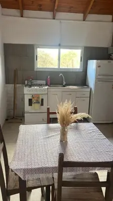 a kitchen with a table and a kitchen with a stove at Cabaña Carmanqui in Alpa Corral