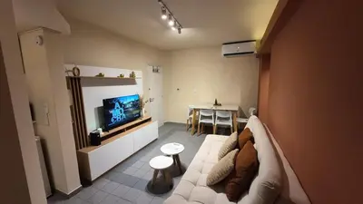 a living room with a white couch and a television at Depto Centro con Patio Pet Friendly La Cañada in Cordoba