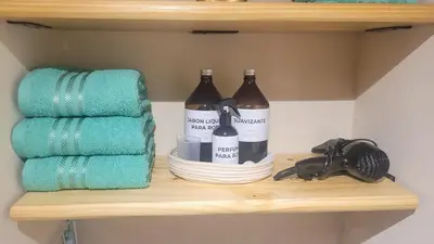 a shelf with two bottles of wine and towels at Depto Centro con Patio Pet Friendly La Cañada in Cordoba