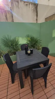 a black table and chairs in a room with plants at Depto Centro con Patio Pet Friendly La Cañada in Cordoba
