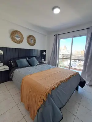 a bedroom with a large bed and a large window at Central y confortable departamento in Cordoba