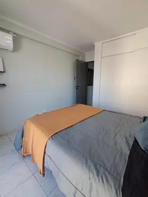 a bedroom with a bed with an orange blanket on it at Central y confortable departamento in Cordoba