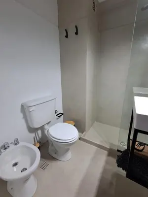 a white bathroom with a toilet and a sink at Central y confortable departamento in Cordoba