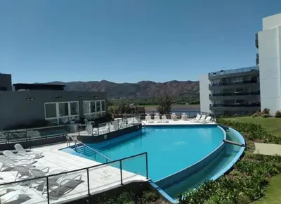 a large swimming pool with chairs and a building at Veneto Village in Villa Parque Siquiman