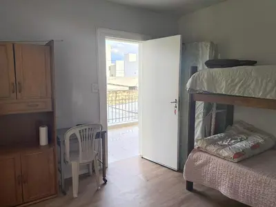 a bedroom with a bed and a door to a balcony at refugio Bv los andes in Cordoba