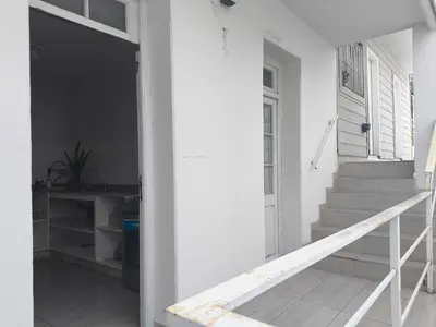 a hallway of a white house with stairs and a door at refugio Bv los andes in Cordoba