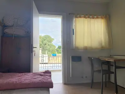 a bedroom with a bed and a table and a window at refugio Bv los andes in Cordoba