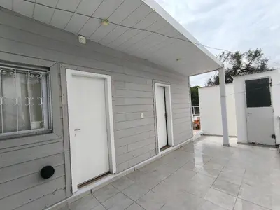 a gray house with white doors and a patio at refugio Bv los andes in Cordoba