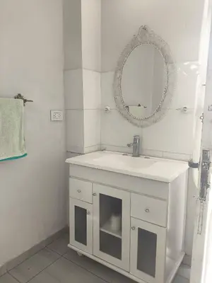 a white bathroom with a sink and a mirror at refugio Bv los andes in Cordoba