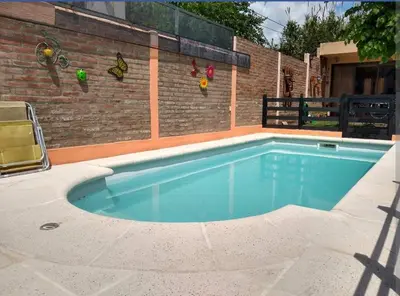 a swimming pool in front of a brick wall at La tranquera Carlos Paz in Villa Carlos Paz