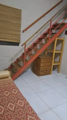 a staircase in a room with a bed and a desk at La tranquera Carlos Paz in Villa Carlos Paz
