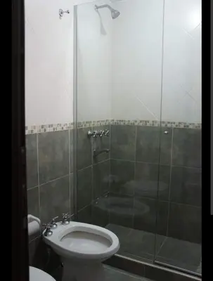 a bathroom with a toilet and a glass shower at La tranquera Carlos Paz in Villa Carlos Paz