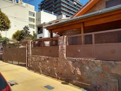 a stone retaining wall next to a building at La tranquera Carlos Paz in Villa Carlos Paz