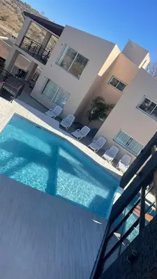 a house with a swimming pool in front of a house at Por Amor a Norma in Potrero de Garay