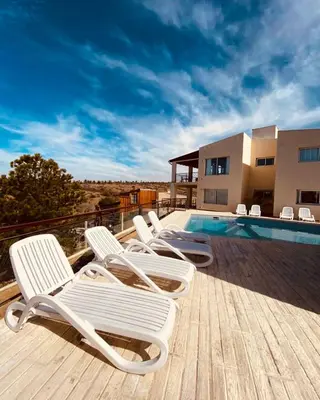 a group of chairs sitting on a deck next to a swimming pool at Por Amor a Norma in Potrero de Garay