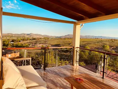 a balcony with a couch and a view of the mountains at Por Amor a Norma in Potrero de Garay