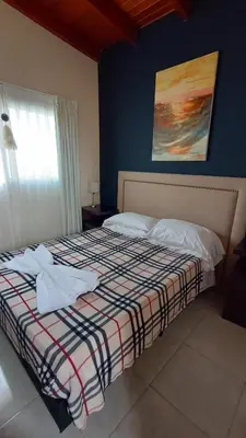 a bedroom with a bed with a checkered blanket at Por Amor a Norma in Potrero de Garay