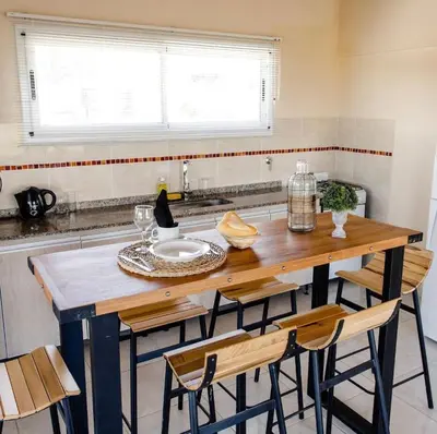 a kitchen with a wooden table and chairs at Por Amor a Norma in Potrero de Garay