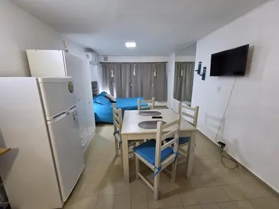 a small kitchen with a table and a refrigerator at Monoambiente cómodo zona centro in Cordoba